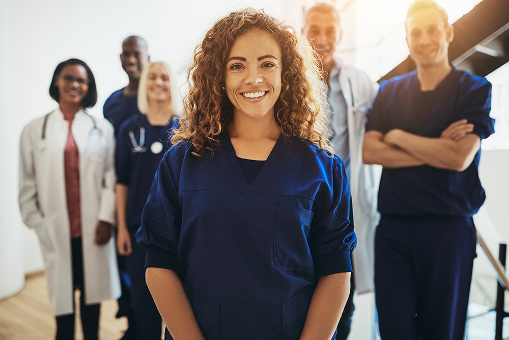 Smiling female doctor standing with medical colleagues in a hospital